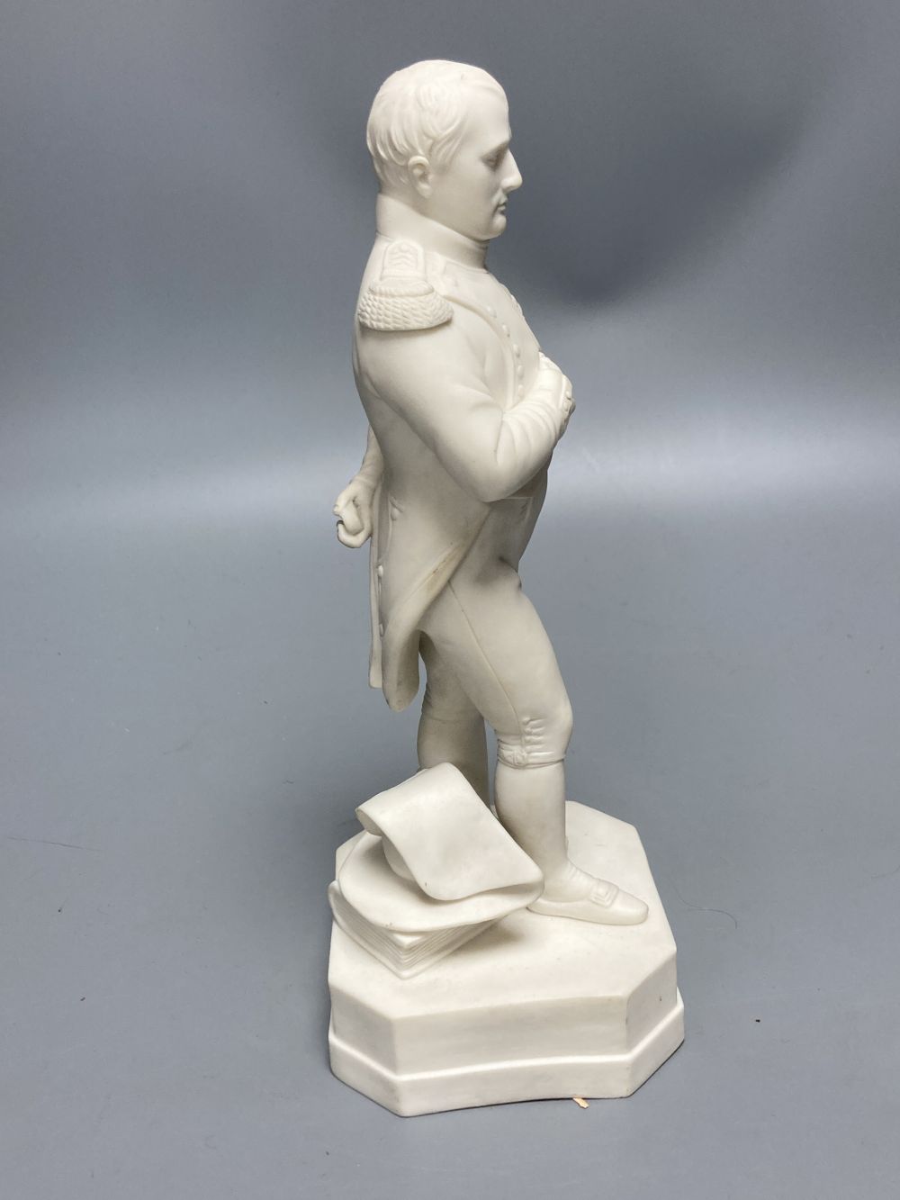 A Robinson & Leadbeater parian figure of Napoleon, standing on shaped square base, 25cm